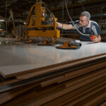 Concentrated grey-haired man leaning on mdf plate while touching new equipment