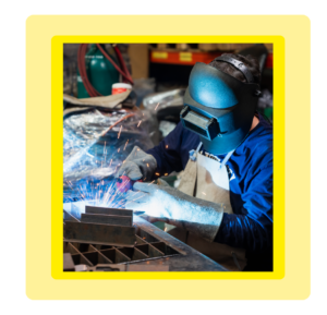 AMS worker welding in a manufacturing facility, showcasing in-house production processes.