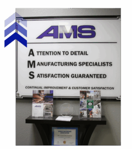 AMS office wall sign showing values like attention to detail and satisfaction, reflecting excellence in fabrication for engineers